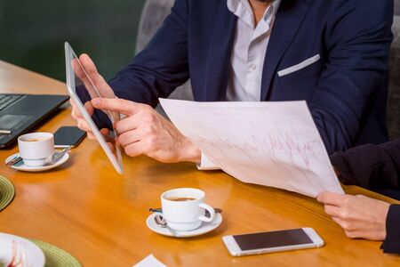 A woman and a man on a business lunch in a restaurant. exploring work on the tablet screenの写真素材