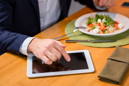 A woman and a man on a business lunch in a restaurant. exploring work on the tablet screenの写真素材