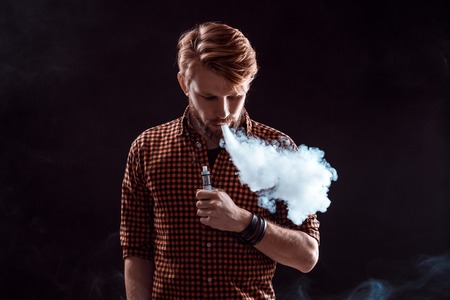 young man smoking electronic cigarette
