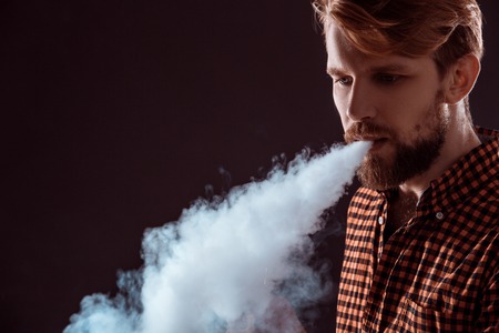young man smoking electronic cigaretteの写真素材