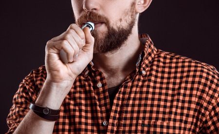 young man smoking electronic cigaretteの写真素材