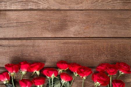 Red roses bouquet over wooden table. Top view with copy space.の写真素材