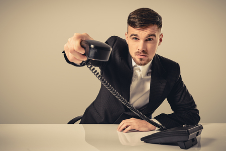 Portrait of attractive businessman holding telephone in his handの写真素材