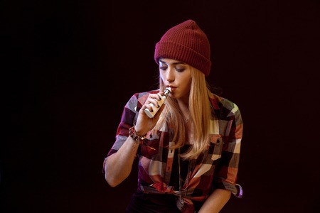 young woman smoking electronic cigaretteの写真素材