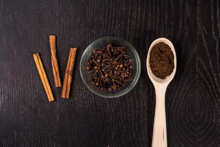 cinnamon sticks, coffee, cloves on black backgroundの写真素材