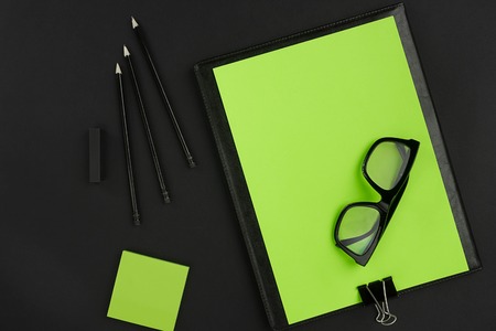 Mix of office supplies on a modern office desk. Black object on a black background. Top view. Still life. Copy spaceの写真素材