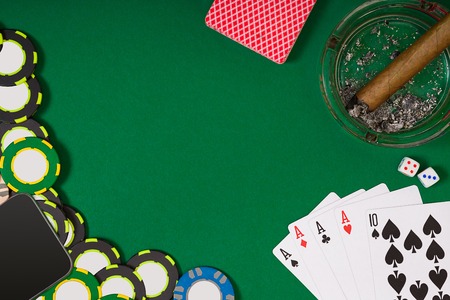 different color chips for gamblings and playing cards on green