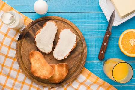 Breakfast table with bread, milk butter, fruits and juice. Top view.の写真素材