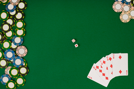 different color chips for gamblings and playing cards on greenの写真素材
