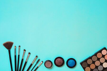 Various cosmetics and brushes on blue background. Top view. Still life. Copy spaceの写真素材
