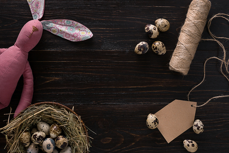 quail eggs in a nest, place for text on wooden rustic background top view close upの写真素材