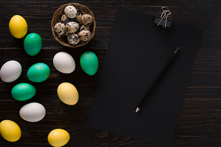 Greeting card with paschal eggs on rustic, wood tableの写真素材