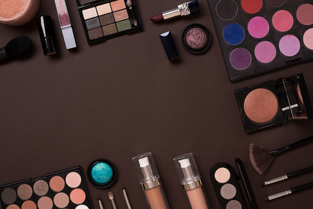The women's cosmetics set on a brown background, modern woman. Brush for makeup, eye shadow, view from above. Copy spaceの写真素材