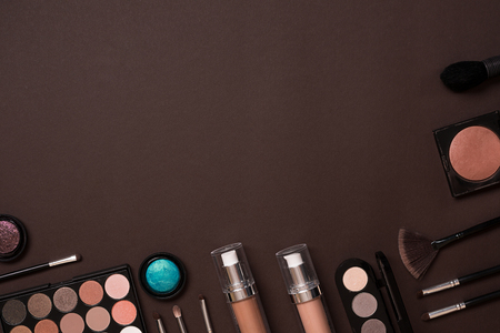 Make up essentials. Set of professional make up brushes, creams and shadows in jars on dark background. Place for your text or logo. Ideal for beauty blog.の写真素材