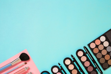 Make up essentials. Set of professional make up brushes, creams and shadows in jars on blue background. Place for your text or logo. Ideal for beauty blog.の写真素材