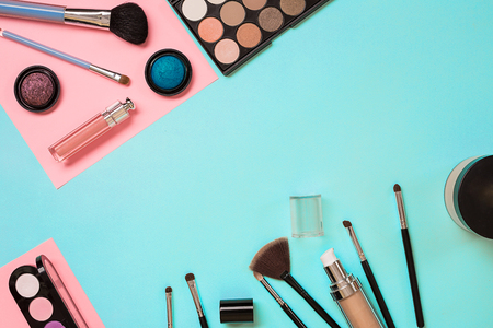 Make up essentials. Set of professional make up brushes, creams and shadows in jars on blue background. Place for your text or logo. Ideal for beauty blog.の写真素材