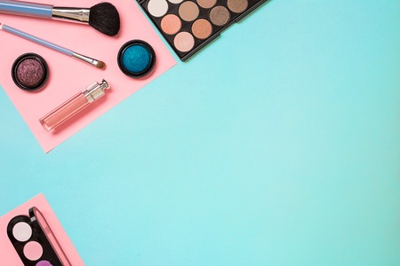 Make up essentials. Set of professional make up brushes, creams and shadows in jars on blue background. Place for your text or logo. Ideal for beauty blog.の写真素材