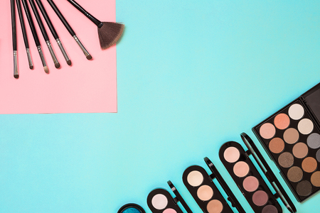 Make up essentials. Set of professional make up brushes, creams and shadows in jars on blue background. Place for your text or logo. Ideal for beauty blog.の写真素材