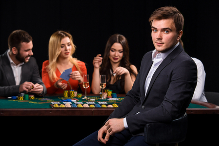 Poker players in casino with cards and chips on black backgroundの写真素材