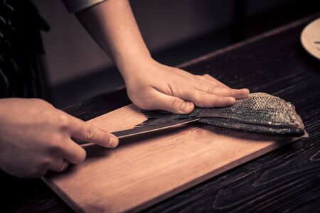 Chef cutting the fish on a boardの写真素材