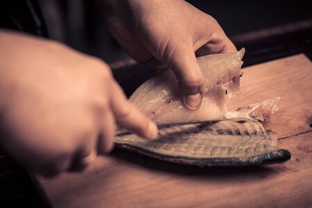 Chef cutting the fish on a boardの写真素材