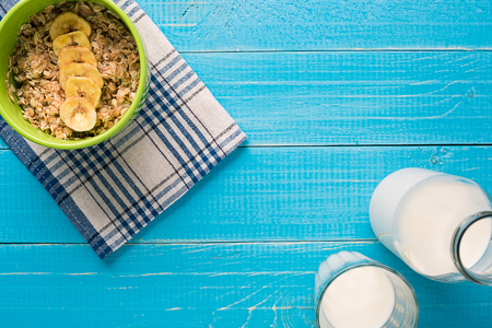 Porridge, oats, milk and banana on the table. Healthy breakfast. View from aboveの写真素材