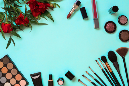 The women's cosmetics set on a blue background, modern woman. Brush for makeup, eye shadow, view from above. Copy spaceの写真素材