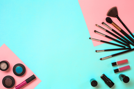 The women's cosmetics set on a blue background, modern woman. Brush for makeup, eye shadow, view from above. Copy spaceの写真素材