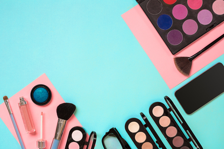 The women's cosmetics set on a blue background, modern woman. Brush for makeup, eye shadow, view from above. Copy spaceの写真素材