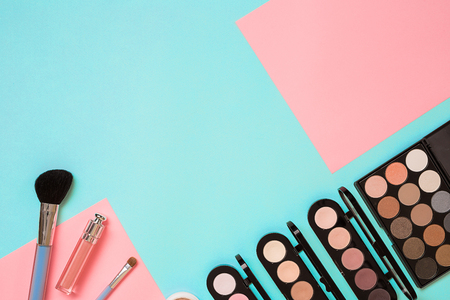 Make up essentials. Set of professional make up brushes, creams and shadows in jars on blue background.の写真素材