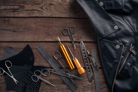 Leather craft or leather working. Leather working tools and cut out pieces of leather on work desk. Still life. Copy space. Top viewの写真素材