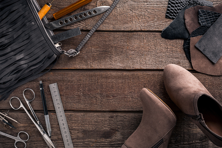 Leather craft or leather working. Leather working tools and cut out pieces of leather on work desk. Still life. Copy space. Top viewの写真素材