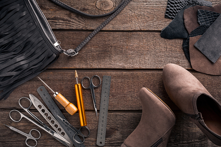 Leather craft or leather working. Leather working tools and cut out pieces of leather on work desk. Still life. Copy space. Top viewの写真素材