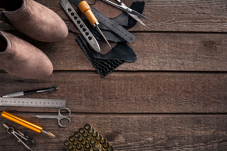 Leather craft or leather working. Leather working tools and cut out pieces of leather on work desk. Still life. Copy space. Top viewの写真素材