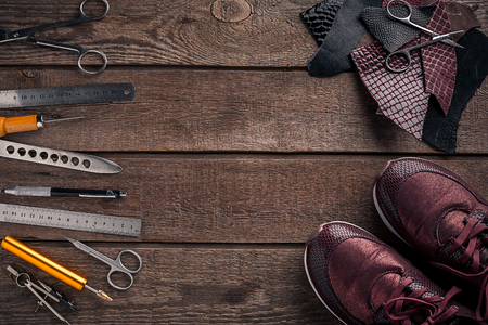Leather craft or leather working. Leather working tools and cut out pieces of leather on work desk .の写真素材