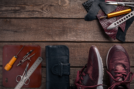 Leather craft or leather working. Leather working tools and cut out pieces of leather on work desk .の写真素材