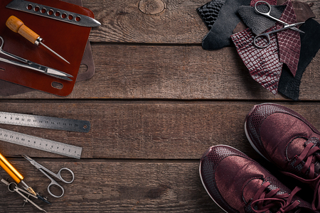Leather craft or leather working. Leather working tools and cut out pieces of leather on work desk .の写真素材