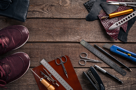 Leather craft or leather working. Leather working tools and cut out pieces of leather on work desk .の写真素材