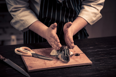 Chef cutting the fish on a boardの写真素材