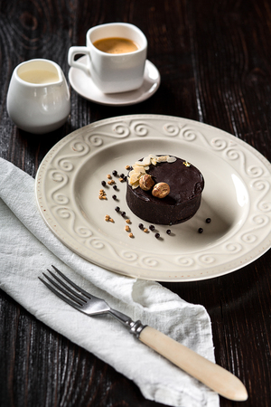 Beautiful decorated chocolate cake with golden nuts and a cup of coffeeの写真素材