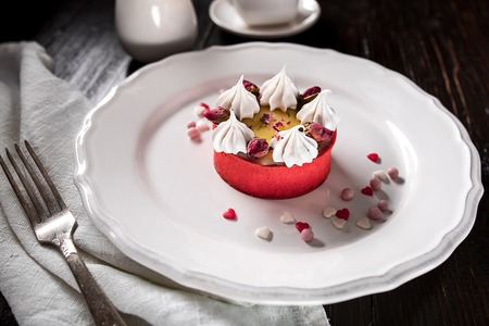 Caramel cheesecake with cream and flowers on the wooden backgroundの写真素材