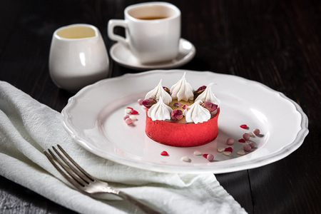 Caramel cheesecake with cream and flowers on the wooden backgroundの写真素材