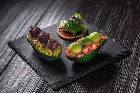 Salmon tartare and avocado salad on a black backgroundの写真素材