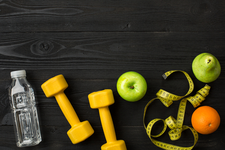 Workout plan with fitness equipment on dark background, top view. Copy space. Still lifeの写真素材