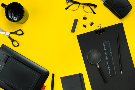 Black objects from the office on a yellow background. Work and creativity. Top view.の写真素材