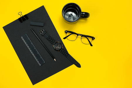 Black objects from the office on a yellow background. Work and creativity. Top view.の写真素材
