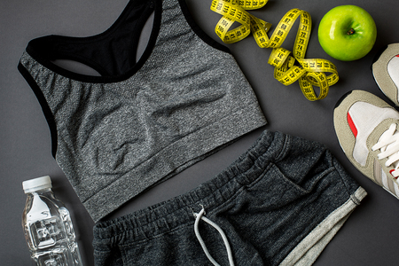 Athletes set with female clothing and bottle of water on dark gray backgroundの写真素材