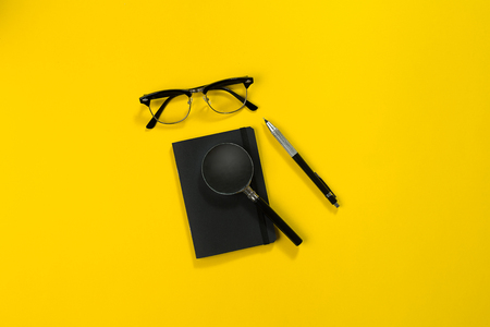 Black objects from the office on a yellow background. Work and creativity. Top view.の写真素材