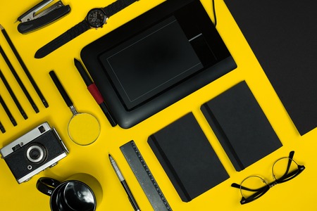 Black objects from the office on a yellow background. Work and creativity. Top view.の写真素材