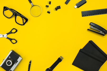 Black objects from the office on a yellow background. Work and creativity. Top view.の写真素材